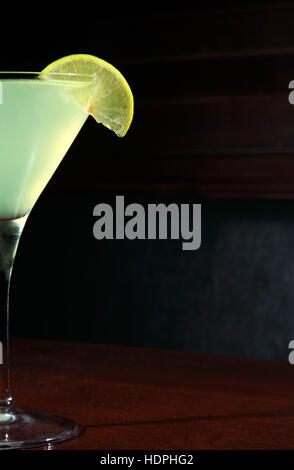 Cocktail appletini avec roue de la chaux, de la vodka, du jus d'ananas, liqueur dans le verre à cocktail martini classique Banque D'Images