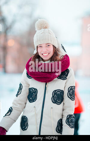 Happy young girl patinage sur une patinoire en plein air Banque D'Images