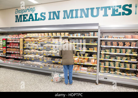Vieil homme shopping pour plats préparés au supermarché Morrisons, London, England, UK Banque D'Images