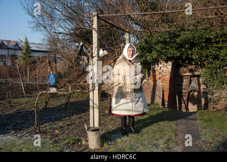 Femme se trouve dans son jardin arrière portant le costume traditionnel de la région du sud de la Moravie Banque D'Images