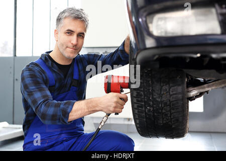 Le remplacement des pneus sur la voiture. Règle le mécanicien l'alignement des roues. Atelier de réparation de voiture, service de pneus. Service pneus, régénération Banque D'Images