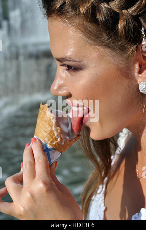 Young Pretty woman eating ice-cream près de la fontaine Banque D'Images