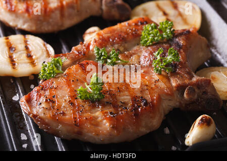 Porc grillé steak juteux avec les oignons et l'ail dans une poêle grill libre horizontale. Banque D'Images