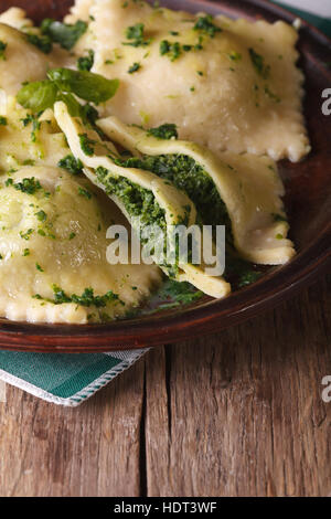 De délicieux ravioli farci aux épinards et fromage sur une plaque verticale brun. Banque D'Images