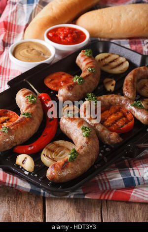 Saucisses, légumes grillés et des brioches avec la sauce sur la table verticale. Banque D'Images