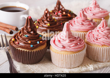 Petits gâteaux de fête avec de la crème et du café sur la table horizontale de près. Banque D'Images