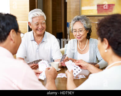 Remorquer senior asian des couples de cartes à jouer ensemble Banque D'Images