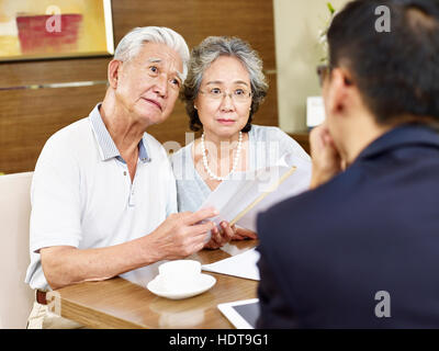 Senior asian couple semblent confus après la lecture d'une proposition Banque D'Images