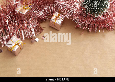 Fond de Noël avec des décorations, des guirlandes de roses et de coffrets cadeaux sur papier naturel Banque D'Images