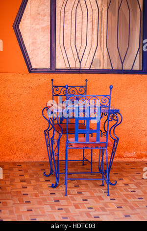 Deux chaises bleues et un tableau bleu en face du mur peint orange Banque D'Images