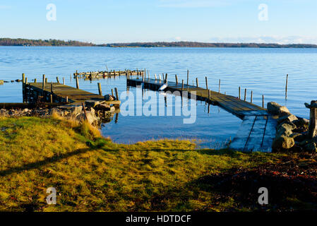 L'eau immobile et calme entourent certains quais de l'archipel. Le matin, soleil d'hiver est la décongélation lentement l'herbe. Kuggeboda emplacement près de Ronneby Banque D'Images