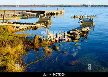 L'eau immobile et calme entourent certains quais de l'archipel. Le matin, soleil d'hiver est la décongélation lentement l'herbe. Kuggeboda emplacement près de Ronneby Banque D'Images