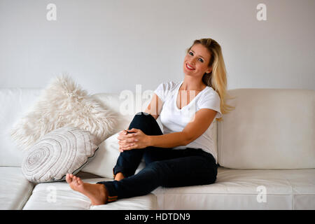 Femme sur canapé, smiling, looking at camera Banque D'Images