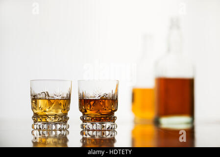 Verres de whisky avec des bouteilles sur fond blanc Banque D'Images