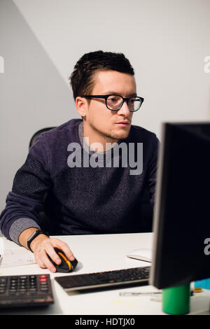 Portrait of smiling businessman travaillant avec l'ordinateur au bureau Banque D'Images