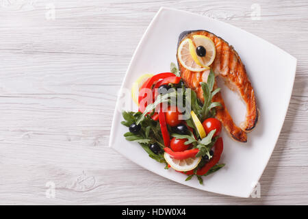Poisson rouge grillé et une salade de saumon sur une plaque horizontale vue du dessus. Banque D'Images