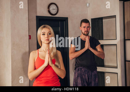 Jeune couple doing yoga exercices de fitness club Banque D'Images