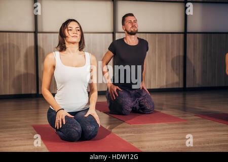 Jeune couple doing yoga exercices de fitness club Banque D'Images