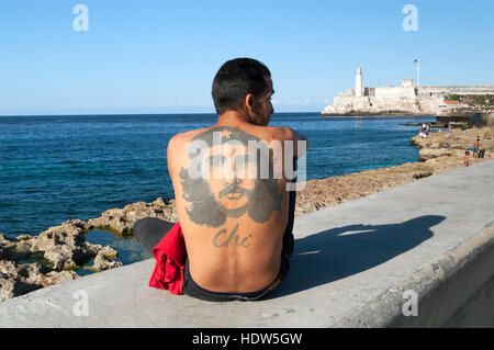 Bad tattoo de Che Guevara sur le dos de l'homme assis sur le mur d'El Malecon, La Havane, Cuba Banque D'Images