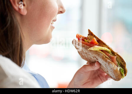 Close up of happy woman eating sandwich panini Banque D'Images