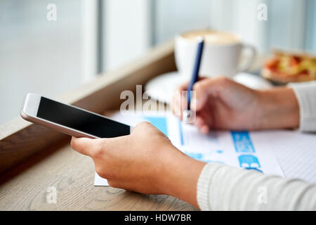 Woman with smartphone et tableau de cafe Banque D'Images