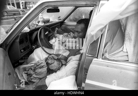 New York, NY - Circa 1989 -- après la ville rasée un bidonville, juste à côté de l'autoroute côté ouest et sud de l'héliport de la 34e rue, à l'aube, ces hommes sans abri a emménagé dans une voiture abandonnée cherchant un refuge contre la tempête de neige. Les préoccupations que les fonctionnaires cités de tentes et d'aérodromes pourraient se laisser prendre à des pales d'hélicoptère. Cette terre a été élaboré et fait maintenant partie de l'Hudson River Park. Banque D'Images