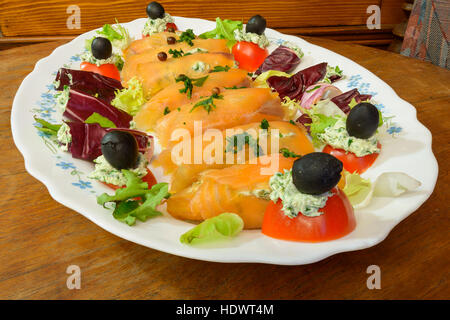 Merveilleux et délicieux rouleaux de saumon fumé avec salade de tomates et fromage olive Banque D'Images