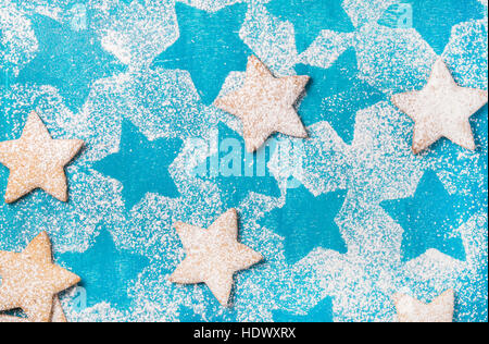 Les cookies en forme de cœur avec du sucre en poudre sur fond bleu lumineux Banque D'Images