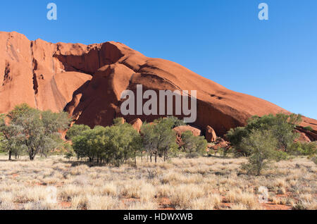 Profil d'Uluru contre plaine désertique et ciel bleu dans le territoire du Nord Australie Banque D'Images