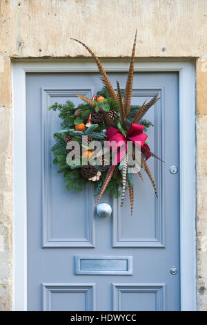 Le feuillage de Noël, couronne de plumes et de fruits sur porte en bois. Arles, France Banque D'Images