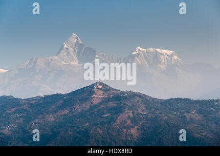 Les sommets de l' Annapurna 3 (7555m) et le machapuchare (6997m) sont visibles dans la brume derrière la crête de la montagne de sarangkot Banque D'Images