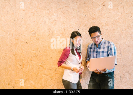 Jeune couple asiatique ou un collaborateur travaillant sur ordinateur portable, des collègues d'affaires occasionnels ou des technologies de l'information concept, with copy space Banque D'Images