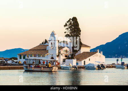 Corfou, Grèce - 30 juin 2011 : les touristes flottent sur un bateau près de monastère de Vlachernes au coucher du soleil Banque D'Images