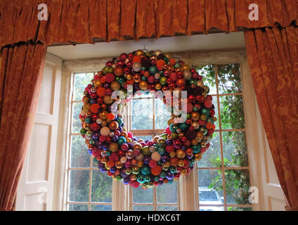 Grande couronne de Noël faite de boules de différentes couleurs dans la fenêtre de suspension Banque D'Images