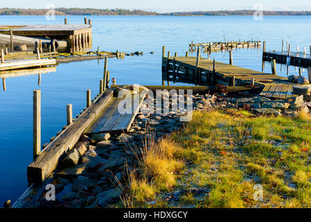 Le calme et la mer sans vent entourent le vieux quais en bois dans l'archipel sur cette journée d'hiver. Kuggeboda emplacement près de Ronneby en Suède. Banque D'Images