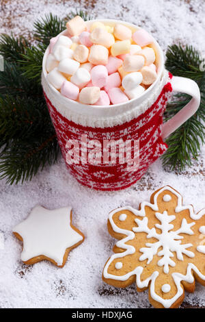 Chocolat chaud avec guimauves fondues en rouge tasse et pain d'épices cookies sur la neige. Vue de dessus avec copie espace Banque D'Images