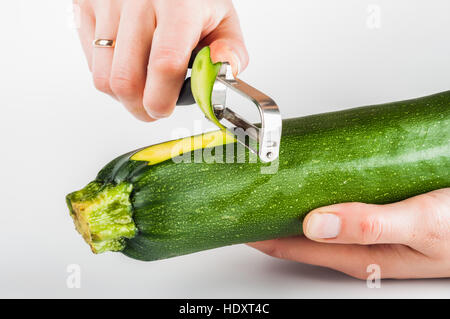Les courgettes avec Peeling peeler sur fond blanc Banque D'Images