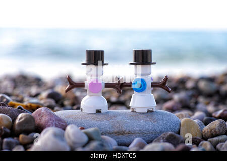 Paphos, Chypre - Novembre 20, 2016 bonhomme Lego et snowwoman debout sur une plage de galets contre la mer. Banque D'Images