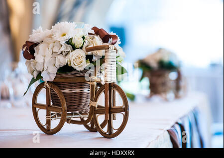 Petit panier en osier avec vélos et des fleurs dans le cadre de décorations de mariage Banque D'Images