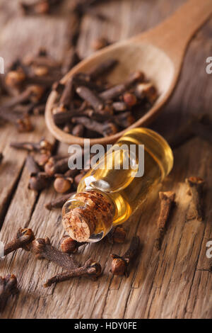 L'essence de girofle dans la bouteille sur la table. De style rustique, vertical Banque D'Images