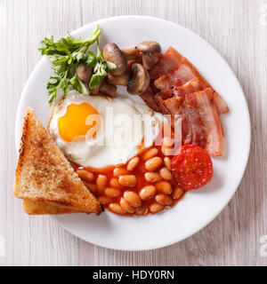 Petit-déjeuner anglais : œuf frit, bacon, haricots et toasts sur une plaque horizontale. close-up Vue de dessus Banque D'Images