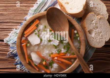 Délicieuse soupe avec du riz et du poulet dans un bol en bois horizontale vue du dessus. Banque D'Images