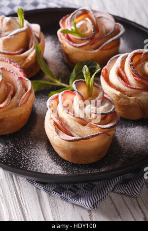 Gâteau aux pommes romantique en forme de roses gros plan sur une plaque verticale. Banque D'Images