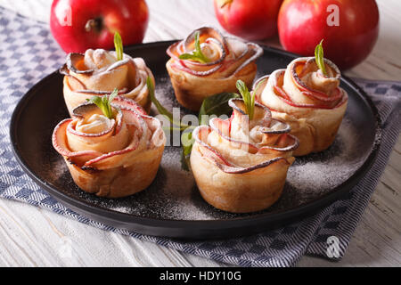 Belles pommes pâtisseries sous la forme de roses gros plan sur une plaque horizontale. Banque D'Images