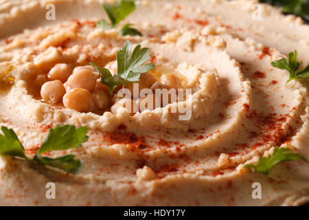 L'hoummos frais avec le paprika et le persil horizontale de macro. Banque D'Images
