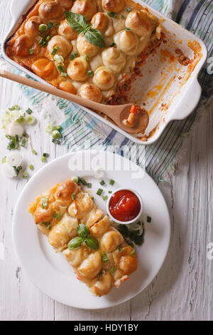 Servant de cottage pie gros plan sur une assiette blanche verticale Vue de dessus. Banque D'Images