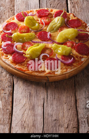 Italian Pizza au salami, pepperoni et poivrons tomates sur une table verticale close-up Banque D'Images