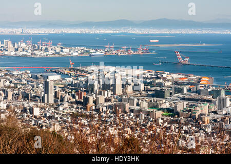 Montagnes Rokko, vue vers le bas de la ville de Kobe, au Japon. Zone de Sannomiya, avec des Rokko Island, la baie d'Osaka et de la ville avec les montagnes en arrière-plan. Banque D'Images