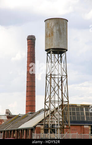 Les structures industrielles abandonnées y compris cheminée en brique et un grand réservoir d'eau surélevé à Geelong, en Australie. Banque D'Images