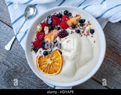 Bol à smoothie banane, la crème glacée aux fruits rouges, les noix, le lin. Parfait pour le régime de detox ou simplement un repas sain. L'amour pour la santé de l'aliment cru concept. Banque D'Images